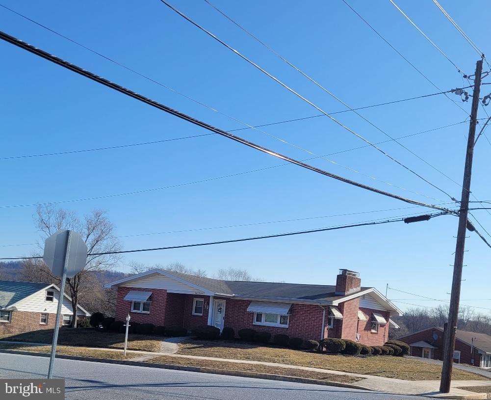 view of front of property with a chimney and brick siding