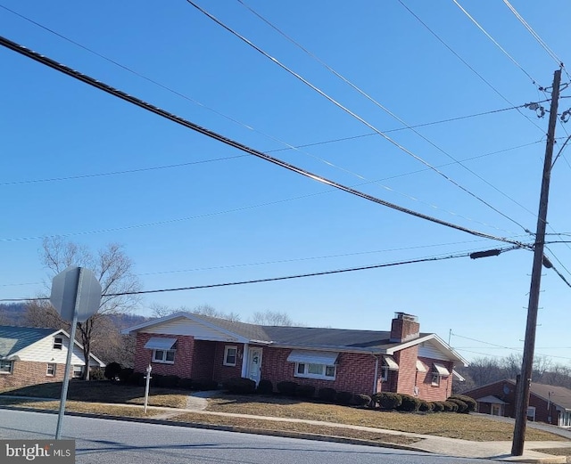 view of front of property with a chimney and brick siding