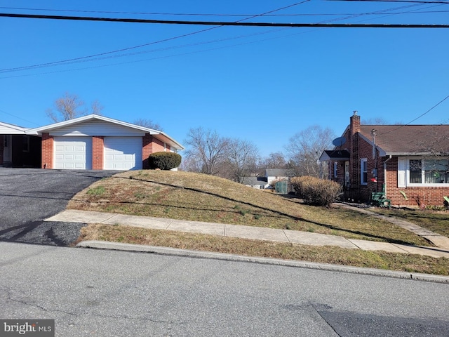 view of yard with a garage and driveway