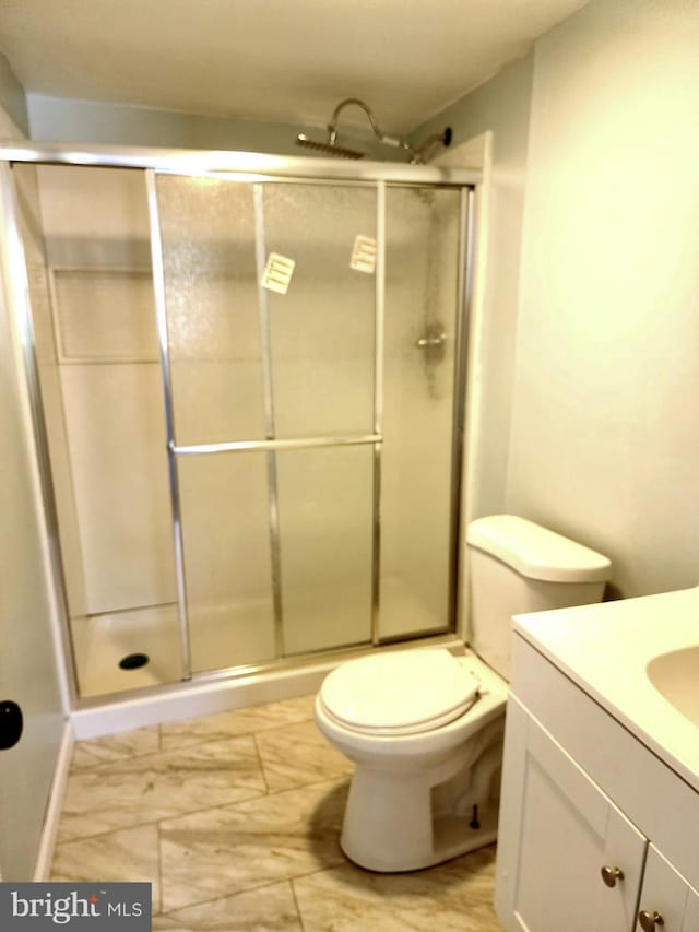 full bath with a stall shower, vanity, and toilet