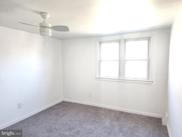 empty room with carpet, baseboards, and a ceiling fan