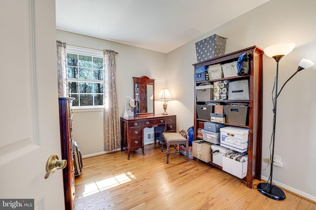 office area with baseboards and wood finished floors