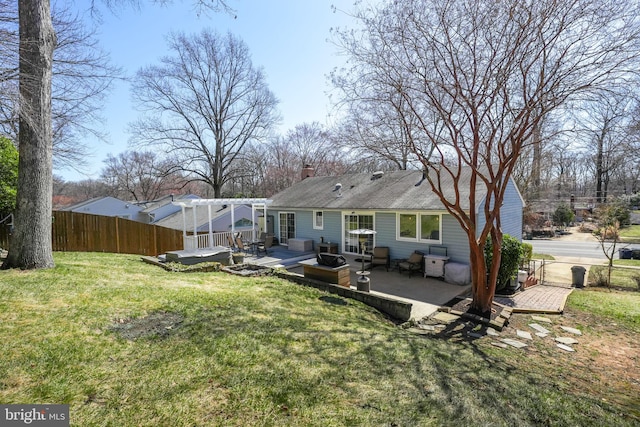 rear view of property with a wooden deck, a yard, and fence