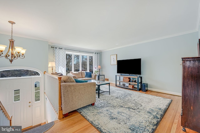 living room featuring baseboards, light wood-type flooring, an inviting chandelier, and ornamental molding