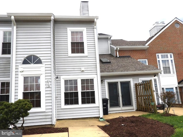 back of house featuring a shingled roof, a chimney, and french doors