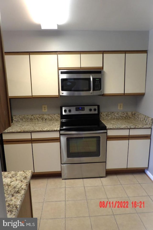 kitchen featuring stainless steel appliances and light tile patterned flooring