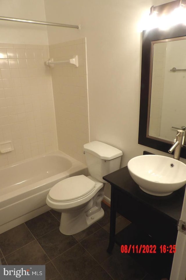 bathroom with toilet, bathing tub / shower combination, vanity, and tile patterned floors