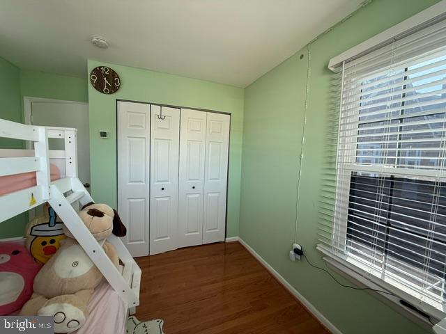 bedroom with a closet, baseboards, and wood finished floors