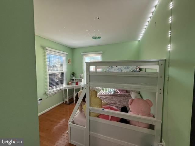 bedroom featuring baseboards and wood finished floors