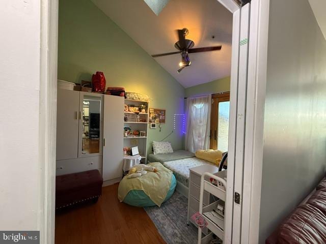 bedroom with lofted ceiling, a ceiling fan, and wood finished floors