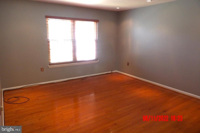 empty room featuring recessed lighting, baseboards, and wood finished floors