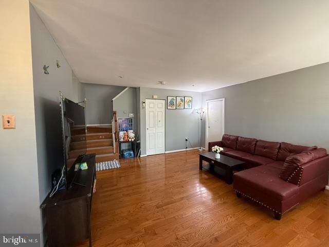 living area with stairway and wood finished floors