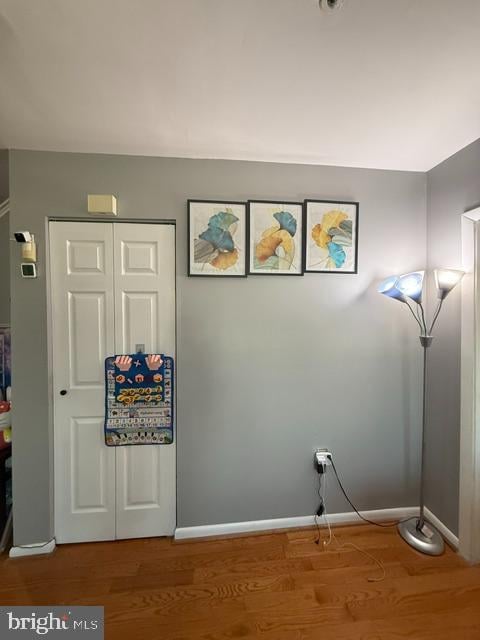 laundry area featuring baseboards and wood finished floors