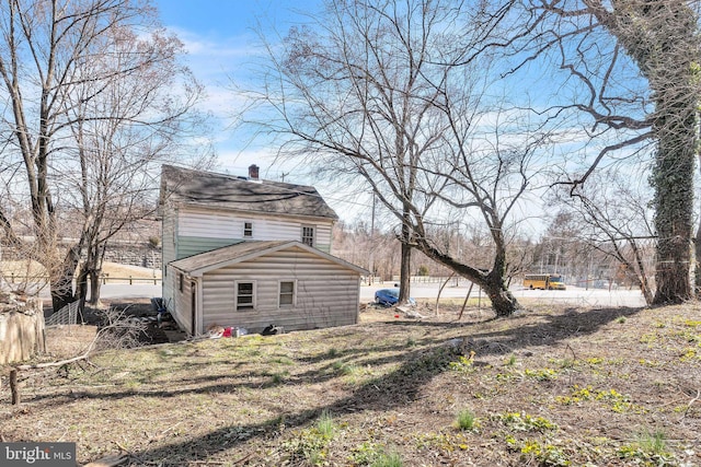 view of property exterior featuring roof with shingles and a chimney