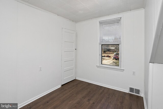 unfurnished room featuring dark wood finished floors, visible vents, and baseboards