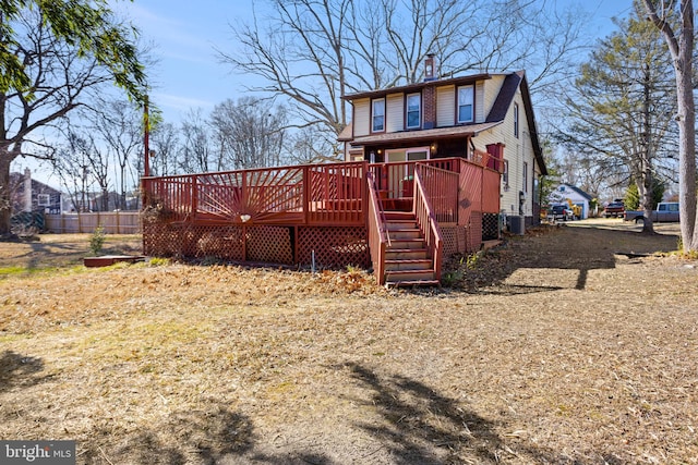 rear view of property with a deck, stairway, and a chimney