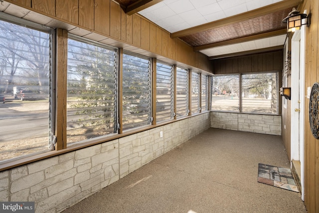 unfurnished sunroom with lofted ceiling with beams