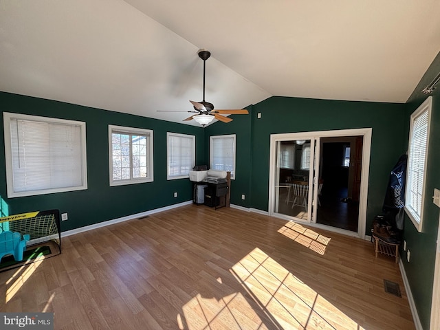 unfurnished sunroom featuring ceiling fan, visible vents, and vaulted ceiling