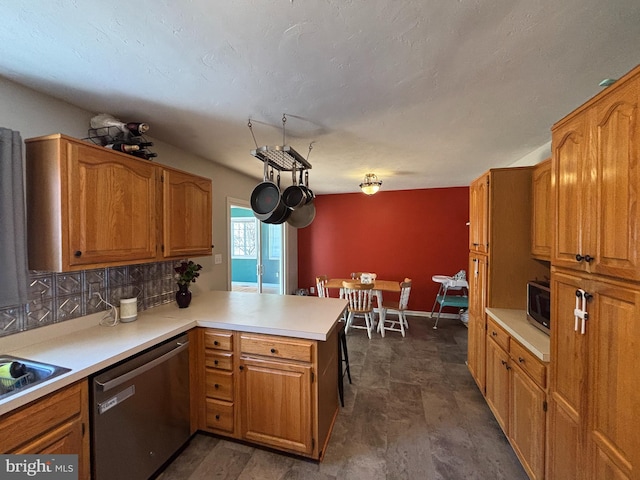 kitchen with dishwasher, a peninsula, stainless steel microwave, and light countertops