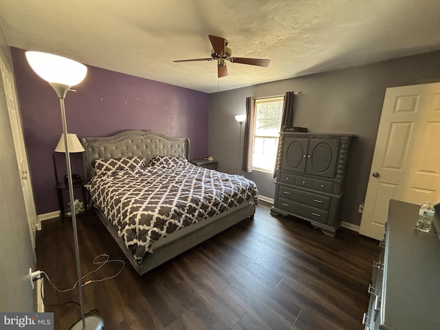 bedroom with a ceiling fan, baseboards, and dark wood-type flooring