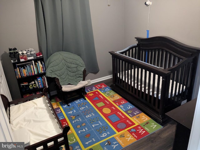 bedroom with baseboards and wood finished floors