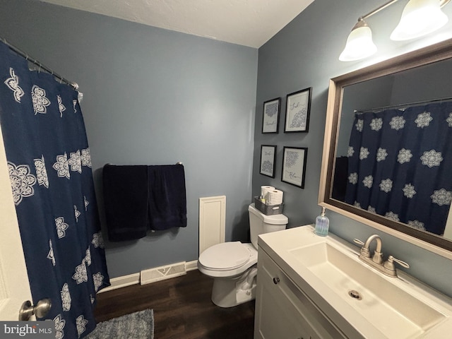 full bathroom featuring toilet, wood finished floors, vanity, visible vents, and baseboards