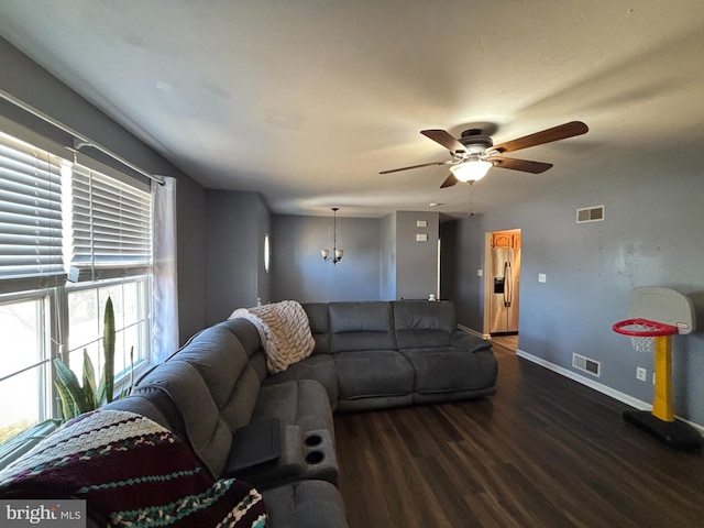 living room featuring a ceiling fan, wood finished floors, visible vents, and baseboards