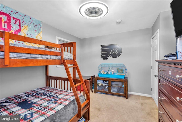 bedroom with light colored carpet and baseboards