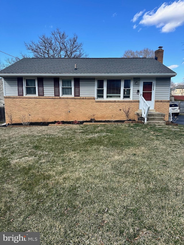 ranch-style home with a front lawn, entry steps, a shingled roof, brick siding, and a chimney