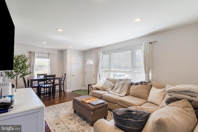 living room with dark wood-type flooring, recessed lighting, and baseboards