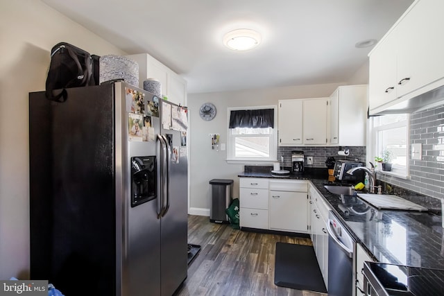 kitchen with decorative backsplash, white cabinets, dark wood-style floors, and appliances with stainless steel finishes