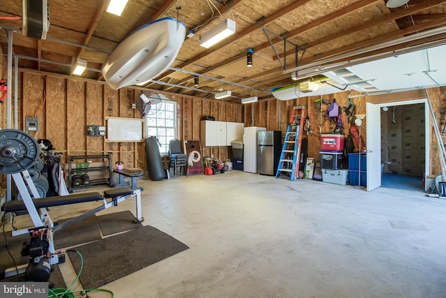 garage with a garage door opener and freestanding refrigerator