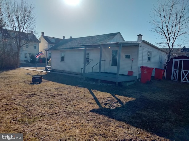 view of front of home featuring an outbuilding, a storage unit, covered porch, and a chimney