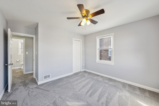 unfurnished bedroom with visible vents, a closet, carpet flooring, baseboards, and ceiling fan