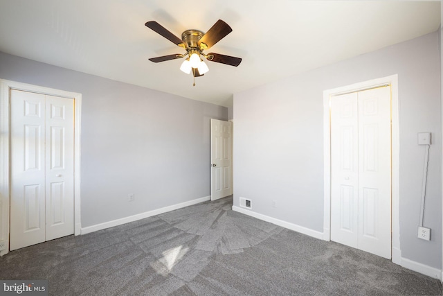 unfurnished bedroom featuring ceiling fan, carpet, baseboards, and multiple closets