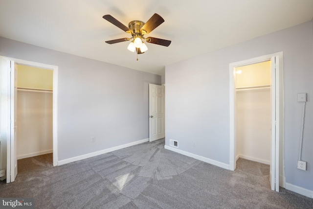 unfurnished bedroom with a walk in closet, carpet flooring, and a closet