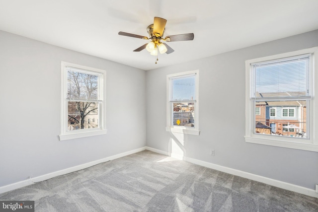 carpeted spare room with baseboards and ceiling fan