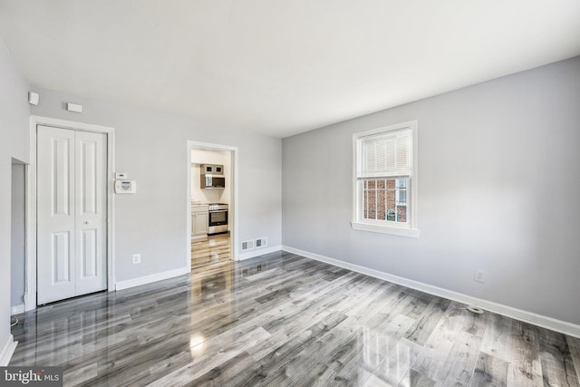 interior space featuring visible vents, wood finished floors, and baseboards