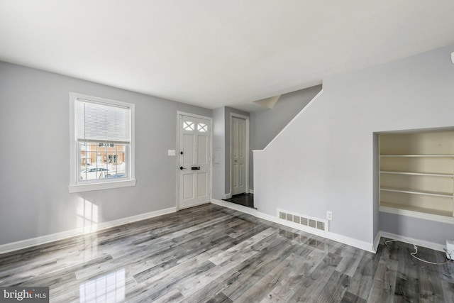 entrance foyer featuring visible vents, baseboards, and wood finished floors