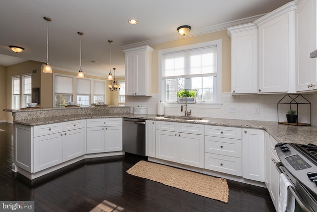 kitchen with decorative backsplash, appliances with stainless steel finishes, a peninsula, white cabinets, and a sink