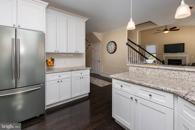 kitchen with backsplash, stainless steel fridge, white cabinetry, a ceiling fan, and dark wood-style flooring