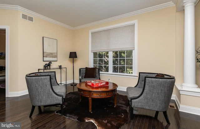 living area with visible vents, crown molding, ornate columns, and wood finished floors