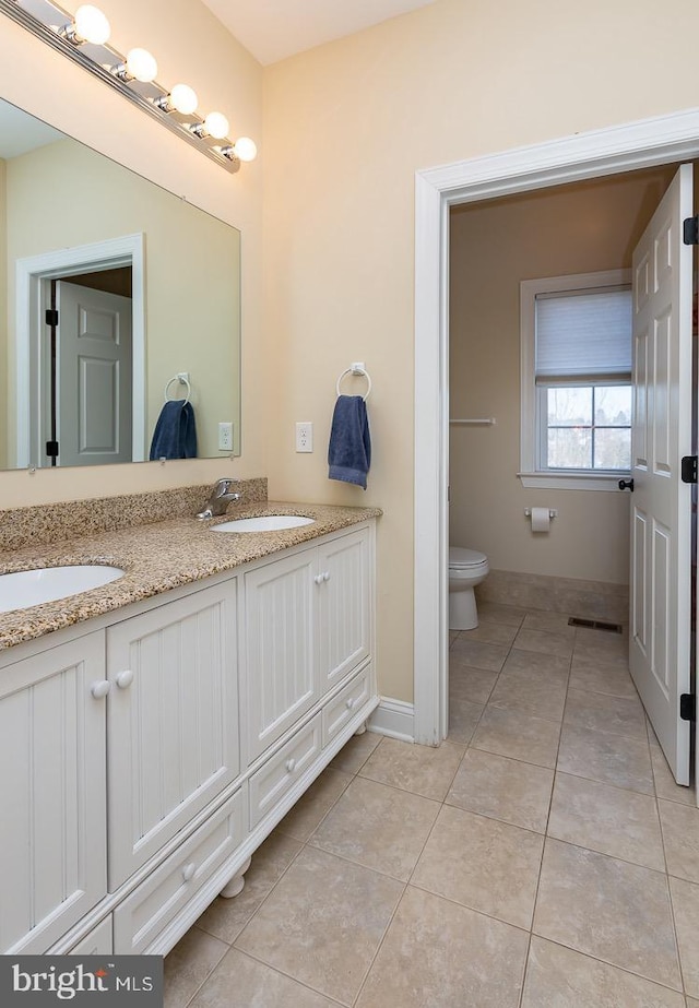 bathroom featuring a sink, visible vents, toilet, and tile patterned floors