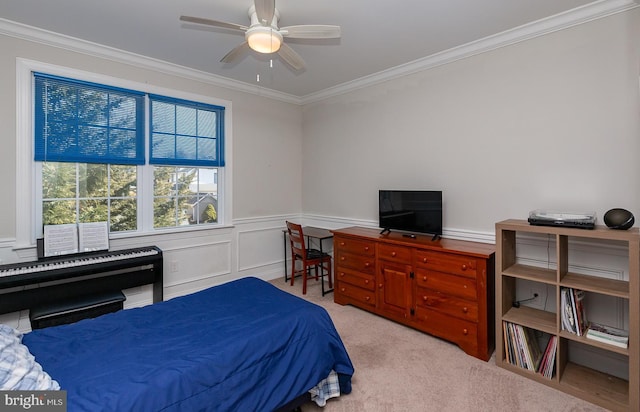 bedroom featuring ceiling fan, carpet, a wainscoted wall, ornamental molding, and a decorative wall