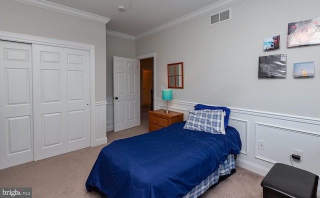 bedroom with visible vents, a closet, a wainscoted wall, and carpet flooring