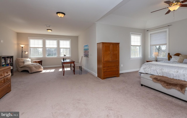 carpeted bedroom with visible vents, multiple windows, baseboards, and ceiling fan