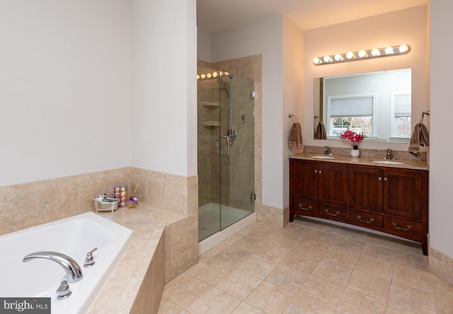 full bathroom featuring a stall shower, a garden tub, and a sink