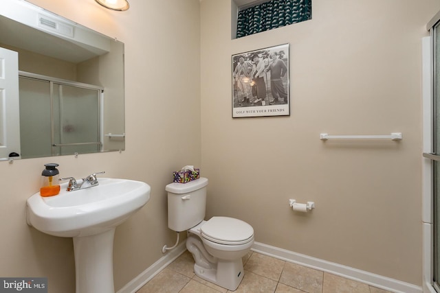 bathroom with tile patterned flooring, visible vents, a shower with door, baseboards, and toilet