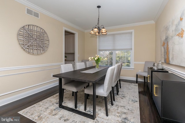 dining space featuring dark wood-type flooring, a notable chandelier, visible vents, and ornamental molding