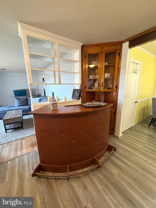 bar featuring crown molding and wood finished floors